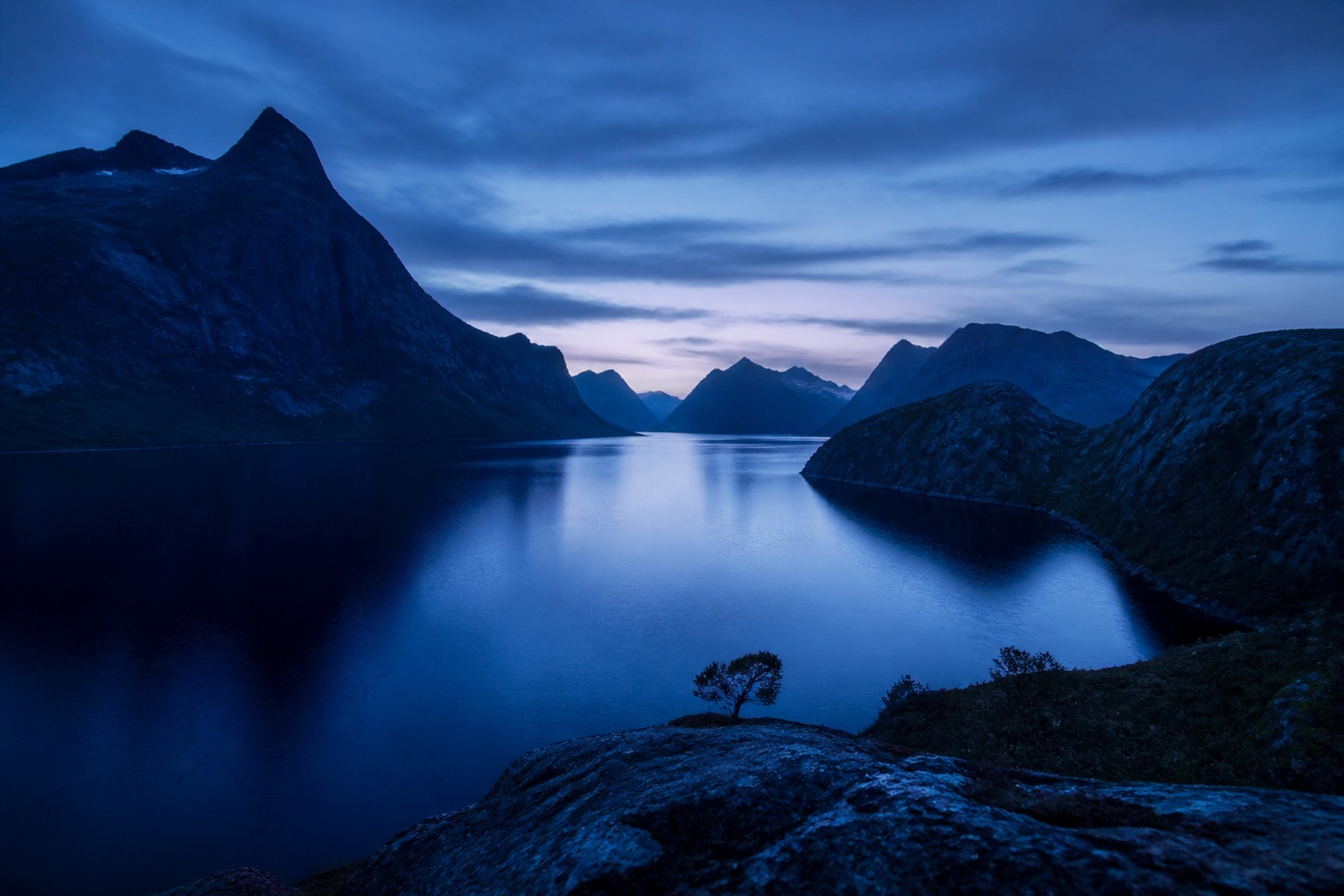 A still Norwegian fjord wrapped in blue hour
